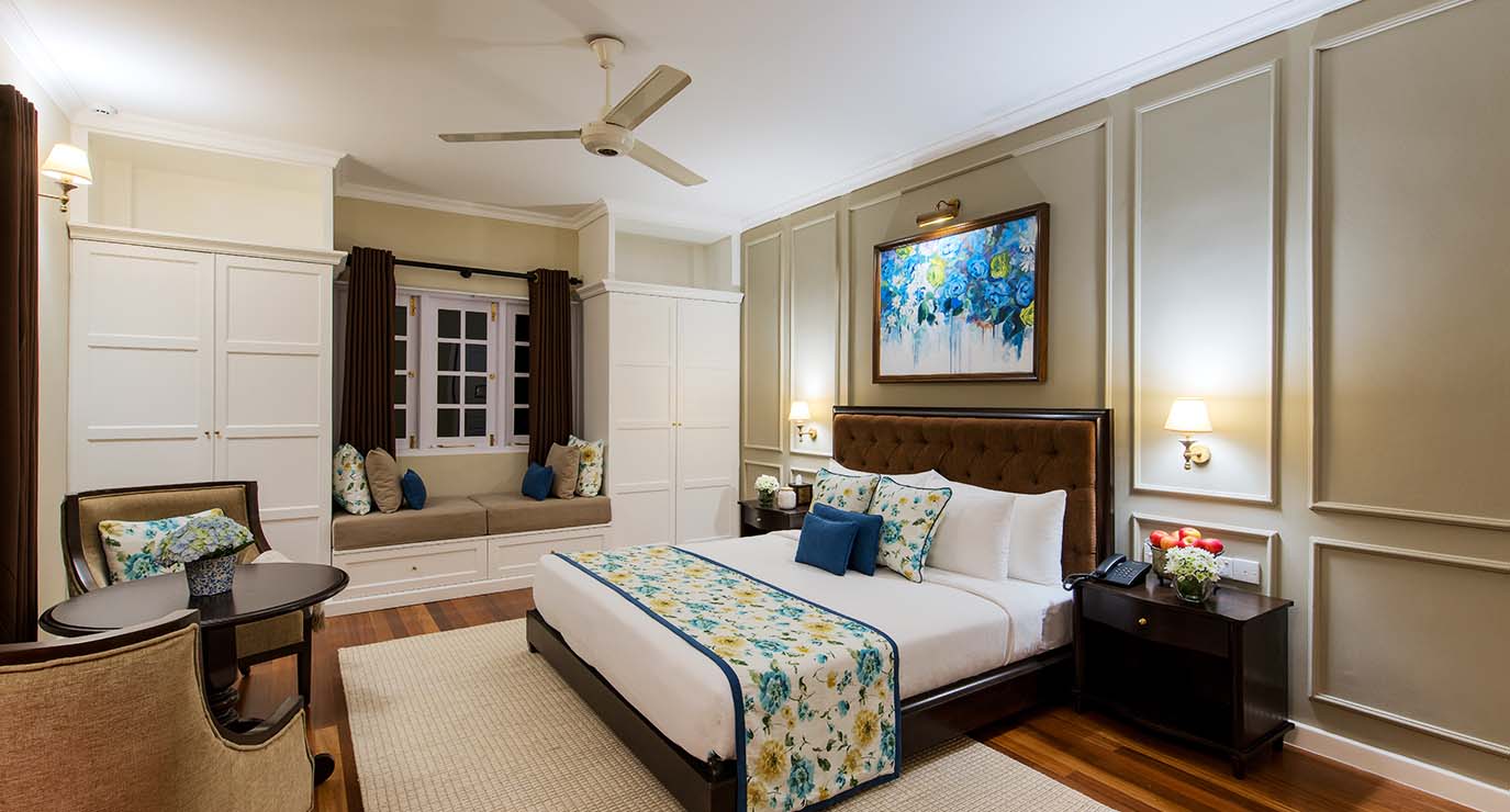 A Premium Room with a double bed, a window seat and a painting above the bed